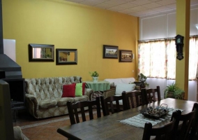 Sala de estar y comedor con chimenea y paredes en amarillo