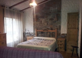 Dormitorio de matrimonio y sillones frente a la cama