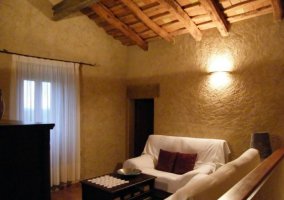 Sala de estar con sillones y cojines burdeos