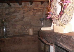 Sala de estar con chimenea encendida y repisa de madera
