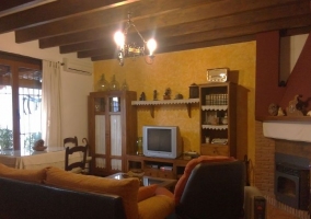 Sala de estar con chimenea y mesa junto a la ventana