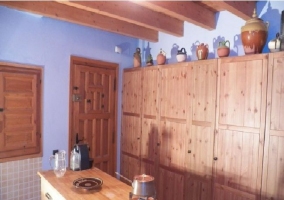 Cocina con armarios de madera y vasijas
