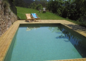 Acceso a la piscina con hamacas de madera