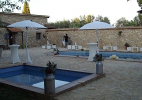 Acceso a las zonas de piscinas con sombrillas blancas