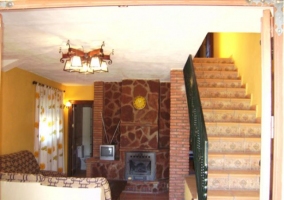 Sala de estar con televisor junto a la chimenea