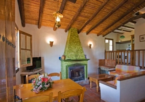 Sala de estar con mesa de comedor y chimenea verde