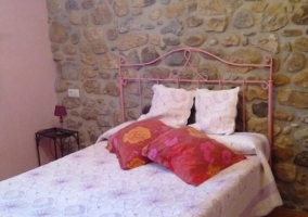 Dormitorio doble con pared en piedra