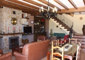 Sala de estar y comedor con la chimenea y escaleras