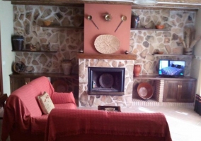 Sala de estar con chimenea y detalles burdeos