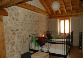 Dormitorio de la casa rural con mesita y cojines de colores