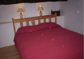 Dormitorio de matrimonio con lamparillas tras el cabecero