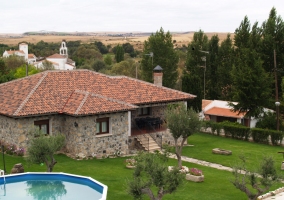Fachada de la casa de piedra con jardín