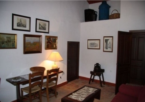 Sala de estar con mesa y pared con cuadros