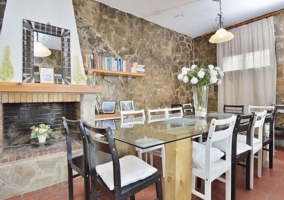 Sala de estar con chimenea frente a la mesa de cristal