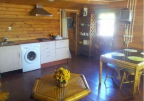 Cocina y sala de estar comunicados con paredes de madera