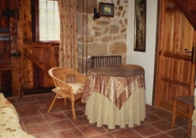 Sala de estar con mesa redonda y pared de piedras