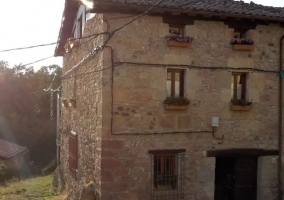 Acceso a la casa con ventanas y plantas en los balcones