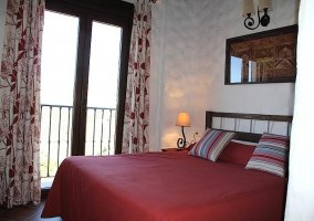 Dormitorio de matrimonio con colcha en rojo