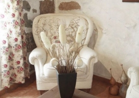 Sala de estar con sillones en blanco y mesa con juego de vajilla