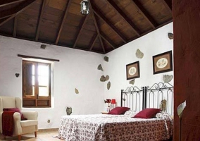 Dormitorio doble con techos altos y cabeceros de forja