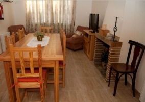 Sala de estar con mesa de madera y chimenea delante