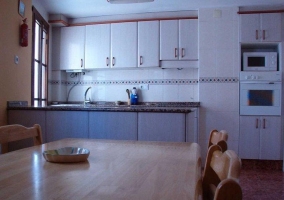 Cocina comedor con mesa de madera y sillas