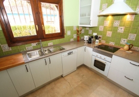 Cocina con detalles en verde y armarios en blancpo