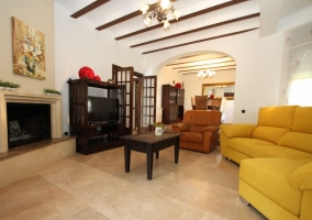 Sala de estar con la chimenea y los sillones tapizados