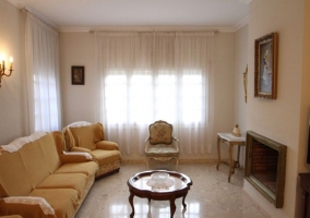 Sala de estar con sillones y una chimenea frente a ellos con cuadro