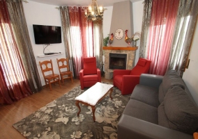 Sala de estar con chimenea y sillones grises y rojos