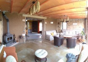 Sala de estar con estufa en una esquina y sillones