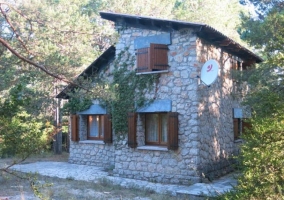 Acceso a la casa con frontal de piedra y ventanas