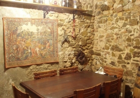 Comedor con mesa de madera y paredes de piedra