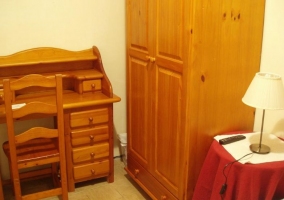 Dormitorio de matrimonio con muebles de madera y escritorio