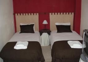 Dormitorio doble con paredes en rojo y colchas