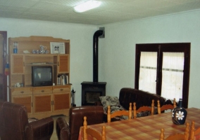 Sala de estar y comedor con televisor y una mesa alargada