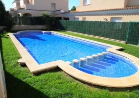 Acceso a la piscina rodeada de espacios verde