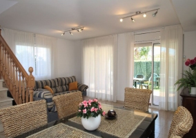 Sala de estar con mesa de comedor y centro de flores rosas