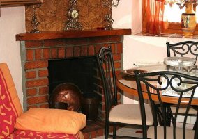 Detalle de la chimenea con mesa y sillón