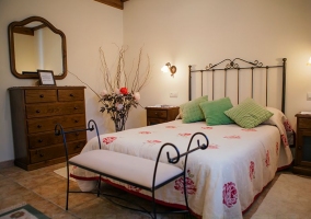 Dormitorio de matrimonio con colcha y tonos rojos