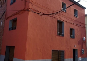 Acceso principal con fachada en gris y burdeos