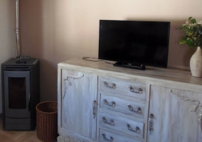 Sala de estar con estufa y muebles desgastados
