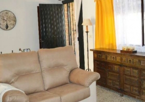 Sala de estar con mueble de madera y cortinas en amarillo