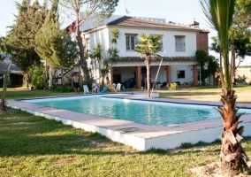 Acceso a la piscina rodeada de espacios verdes