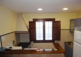 Sala de estar con mesa al fondo y cocina americana