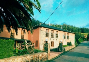 Acceso principal a la vivienda con muro de piedra