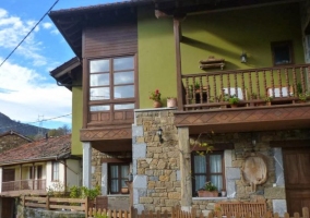 Sala de estar con chimenea en la esquina y cesta de maderas