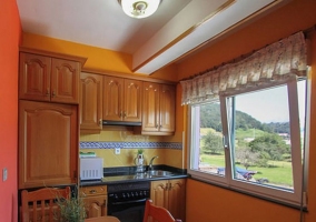 Cocina con mesa de madera y suelos