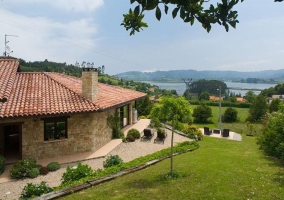 Acceso y vistas de la casa con jardines alrededor