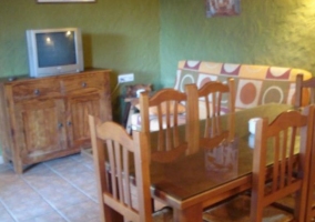 Cocina junto a la zona de comedor con mesa de madera y sillas